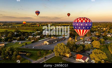 Une vue panoramique d'une ville avec une longue route ci-dessous et un tableau coloré de ballons flottant dans les airs au-dessus Banque D'Images
