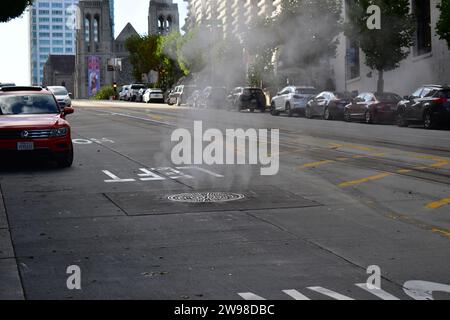 De la vapeur chaude s'échappe d'un trou d'homme sur California Street dans le centre-ville de San Francisco Banque D'Images