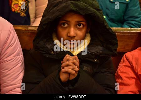 Srinagar, Inde. 25 décembre 2023. Un dévot chrétien prie à l'intérieur de l'église catholique de la Sainte famille pendant les célébrations de Noël à Srinagar. La région himalayenne du Cachemire a une minuscule population de chrétiens, dont des centaines se joignent à la messe à l'église catholique de la Sainte famille à Noël et prient pour la paix et la prospérité de la région. Crédit : SOPA Images Limited/Alamy Live News Banque D'Images