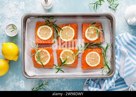 Saumon. Filet de poisson de saumon cru frais avec des ingrédients de cuisine, romarin et citron, vue de dessus Banque D'Images