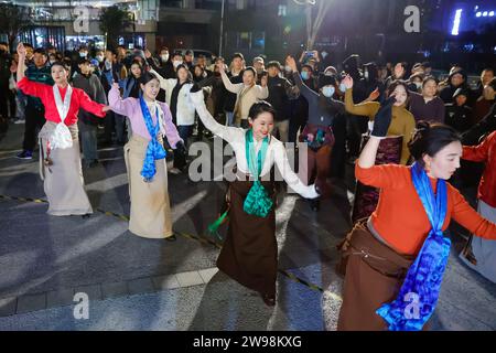 Chengdu, province chinoise du Sichuan. 23 décembre 2023. Les gens dansent le Guozhuang sur une place à Chengdu, dans la province du Sichuan, dans le sud-ouest de la Chine, le 23 décembre 2023. POUR ALLER AVEC 'Across China : Traditional Tibetan danse son chemin dans la vie urbaine' crédit : Shen Bohan/Xinhua/Alamy Live News Banque D'Images