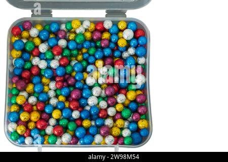 Une pile de petites boules colorées en thermocol dans une boîte en plastique isolée sur un fond blanc. Banque D'Images