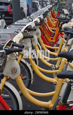 Location de vélos alignés dans une rangée en public à Milan, Italie Banque D'Images