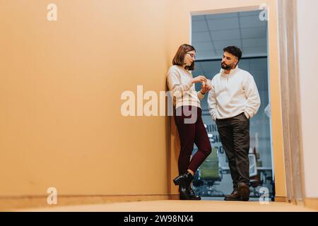 Employé masculin flirtant avec son collègue au travail. Banque D'Images