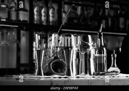 Ensemble d'accessoires de bar pour faire des cocktails, situé sur le bar, derrière est une étagère avec des liqueurs et de l'alcool fort. Supports mixtes Banque D'Images