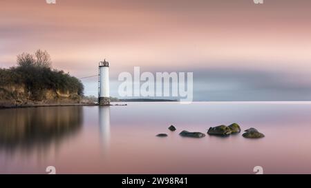 Longue exposition d'un coucher de soleil coloré derrière le phare abandonné sur la côte de la mer Baltique à Maltzien sur Ruegen, Allemagne Banque D'Images