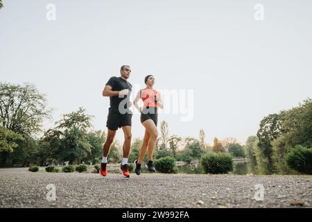 Couple actif profitant de l'entraînement en soirée dans le parc naturel Banque D'Images