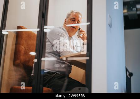 Un homme d'affaires discutant de la stratégie de marketing et des stratégies publicitaires lors d'un appel téléphonique, en se concentrant sur la croissance des revenus et des bénéfices. Banque D'Images