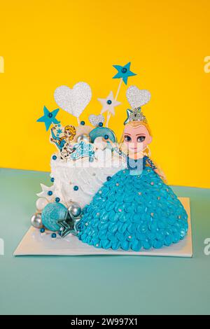 Un plan vertical d'un gâteau d'anniversaire sous la forme d'une fille avec une robe bleue Banque D'Images