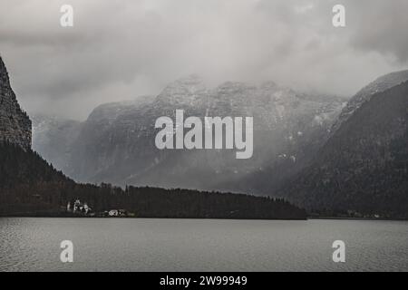 Les majestueuses montagnes enneigées surplombent un lac de montagne immaculé à Hallstatt, en Autriche Banque D'Images