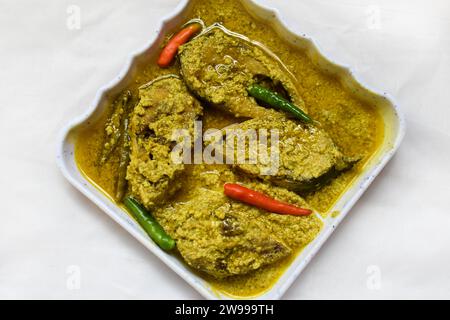 Une assiette blanche avec un délicieux assortiment de poissons hilsa recouverts de piment vert aromatique Banque D'Images