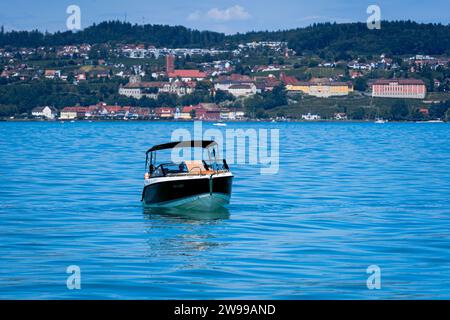 Un bateau solitaire se trouve au milieu du vaste océan ouvert, son pont désert et ses couleurs fanées évoquant un passé d'aventures oubliées depuis longtemps Banque D'Images