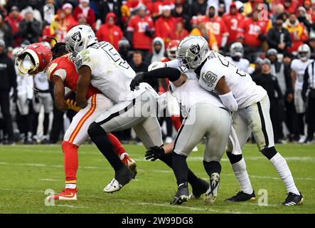 Kansas City, États-Unis. 25 décembre 2023. Le coureur arrière des Chiefs de Kansas City Isiah Pacheco perd son casque alors qu'il est attaqué par Divine Deablo, le linebacker des Raiders de Las Vegas, lors de la seconde moitié de la victoire des Raider au stade Arrowhead de Kansas City, Missouri, le lundi 25 décembre 2023. Photo de Dave Kaup/UPI crédit : UPI/Alamy Live News Banque D'Images