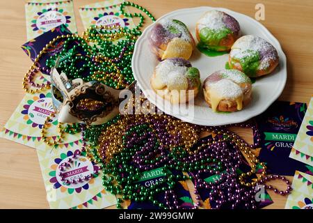 Plusieurs symboles de Mardi gras tels que le masque de carnaval, les perles colorées, les cartes postales de voeux créatives faites à la main et la nourriture traditionnelle sur la table Banque D'Images