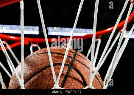 Un gros plan d'un ballon de basket tombant à travers le filet pour marquer des points Banque D'Images