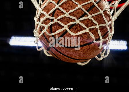 Un gros plan d'un ballon de basket tombant à travers le filet pour marquer des points Banque D'Images