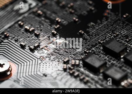 Carte de circuit imprimé noire avec micropuces et condensateurs, macro photo avec mise au point sélective douce Banque D'Images