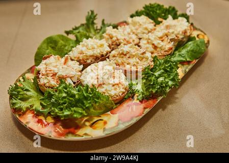 Une image alléchante de la cuisine maison avec une délicieuse salade disposée sur un plateau en marbre La salade est composée de feuilles de laitue fraîches et de bâtonnet de crabe Banque D'Images