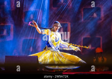 Portrait d'une jeune belle artiste féminine exécutant de la danse sur une chanson pendant la foire de pushkar en robe colorée ethnique rajasthani. Banque D'Images