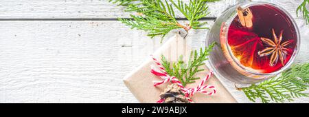 Composition festive avec boîte cadeau en papier et verre à vin chaud, sur une table en bois avec sapin de Noël. Bonne année et vœux de Noël ca Banque D'Images