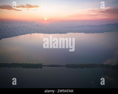 Hangzhou. 26 décembre 2023. Cette photo aérienne prise le 26 décembre 2023 montre le paysage du lac de l'Ouest au lever du soleil à Hangzhou, dans la province du Zhejiang dans l'est de la Chine. Crédit : Jiang Han/Xinhua/Alamy Live News Banque D'Images