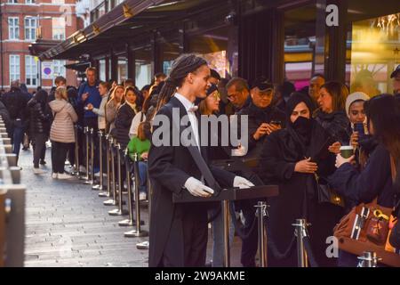 Londres, Royaume-Uni. 26 décembre 2023. Les membres du personnel servent des pâtisseries et des boissons chaudes pendant que les clients font la queue devant Harrods à Knightsbridge pour la vente de Boxing Day. Crédit : Vuk Valcic/Alamy Live News Banque D'Images