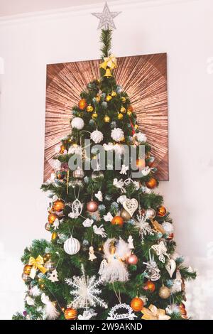 Arbre de Noël décoré avec des ornements dorés, bronze et blancs avec une image en arrière-plan Banque D'Images