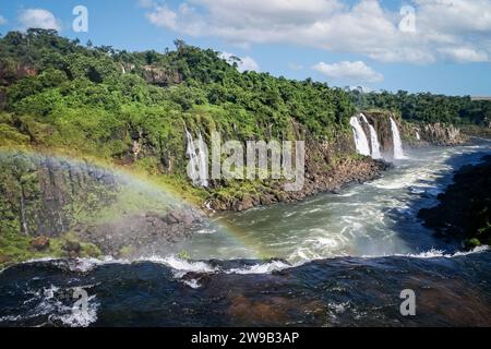 Eau en cascade sur les chutes avec arc-en-ciel et chutes multiples en aval aux chutes d'Iguaçu, Brésil Banque D'Images