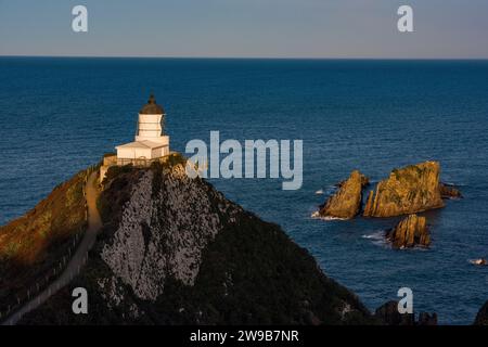 Un phare majestueux perché sur une falaise surplombant l'océan, Nugget point, Nouvelle-Zélande Banque D'Images