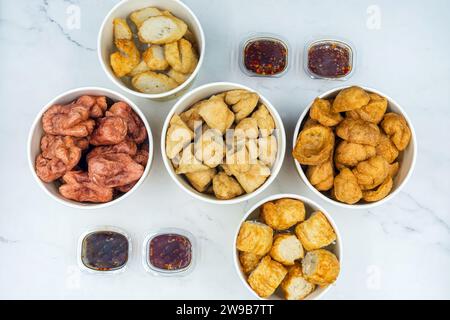 Les boulettes de viande frites faites à partir d'une variété de viandes et de saucisses, mélangées avec de la farine et des assaisonnements avec une délicieuse sauce épicée sur fond de marbre blanc. Banque D'Images