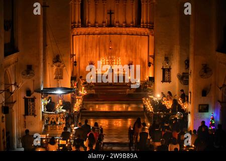 Les dévots chrétiens assistent à une messe de minuit à St. Église de la cathédrale James. Prières de la messe de minuit avec des bougies à l'occasion de Noël à St. James Church. Noël est un festival annuel commémorant la naissance de Jésus-Christ célébré dans le monde entier. Banque D'Images