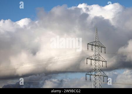 Impression vom RWE-Kraftwerk Bergheim Niederaußem. DAS Kohlekraftwerk zieht seine Schwaden in die kalte Winterluft. In der Umgebung glänzen Strommasten, Windräder und Wolkenformationen in der kalten Wintersonne. Stadtwerke geben bekannt : Strompreise steigen für Privathaushalte 2024 UM 32 Prozent. Grund ist eine Entscheidung der Bundesregierung, Gelder in Höhe von 5,5 Milliarden zur Stabilisierung der Netzentgelte zu streichen. Themenbild, Symbolbild. Bergheim, 26.12.2023 NRW Deutschland *** impression de RWEs centrale Bergheim Niederaussem la centrale à charbon coule dans le col Banque D'Images