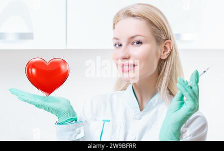 Portrait d'une fille blonde en robe médicale. Elle tient un cœur rouge dans sa paume. Concept de Cardiologie et Transplantologie. Supports mixtes Banque D'Images