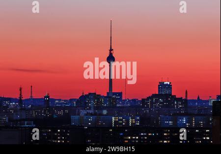 Coucher de soleil avec coucher de soleil, vous pouvez voir la tour de télévision de Berlin, l'hôtel de ville rouge, la tour de la radio, les lumières dans les bâtiments résidentiels, Berlin, 01.03.2023 Banque D'Images