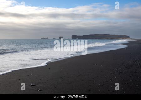 Côte de l'océan Atlantique au sud de l'île. Célèbre plage de sable noir avec ses formations rocheuses. Ciel nuageux en automne. Reynisfja Banque D'Images