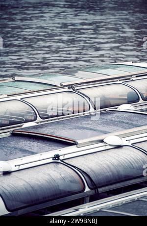 Détail de bateaux de tourisme vides amarrés sur un canal à Amsterdam, aux pays-Bas Banque D'Images