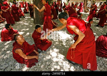 Les moines bouddhistes au monastère de sera à Lhassa gestes alors qu'ils débattent dans la cour du monastère. Banque D'Images