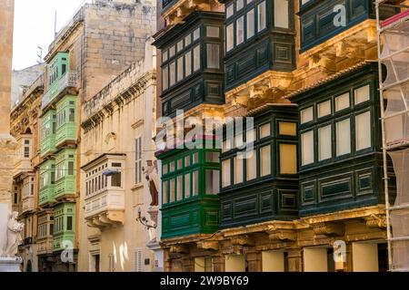 Vue sur la rue de la Valette avec balcons typiques sur les façades de la maison. La Valette, Malte Banque D'Images