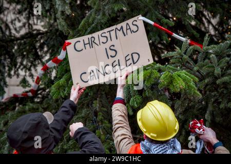 Schiedam, Schiedam, pays-Bas. 26 décembre 2023. Les activistes placent un panneau de protestation indiquant ''Noël est annulé''. . Le 26 décembre 2023, devant le sapin de Noël annuel de l'hôtel de ville de Rotterdam, les militants de extinction Rebellion ont protesté contre la mort d'enfants à Gaza. Avec le message «Noël est annulé», ont-ils demandé, comment peut-on célébrer Noël quand, dans la terre de la naissance de Jésus, des enfants sont tués chaque jour? (Image de crédit : © James Petermeier/ZUMA Press Wire) USAGE ÉDITORIAL SEULEMENT! Non destiné à UN USAGE commercial ! Banque D'Images