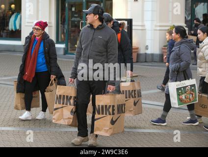 Richmond, Canada. 26 décembre 2023. Les gens portent des sacs à provisions le lendemain de Noël à Richmond, Colombie-Britannique, Canada, le 26 décembre 2023. Le lendemain de Noël est l'un des plus grands jours de magasinage au Canada. Crédit : Liang Sen/Xinhua/Alamy Live News Banque D'Images