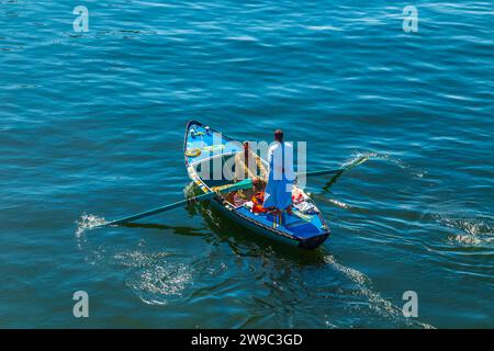 Les vendeurs de textiles sur leurs bateaux approchent un bateau de croisière en attendant d'entrer dans l'écluse d'Esna. Les vendeurs espèrent vendre des marchandises aux touristes. Esna, Égypte – octobre 20 Banque D'Images