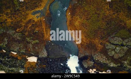 Drone shot de la cascade nordique oxarafoss en islande, paysage arctique spectaculaire avec une énorme cascade et des collines. Fantastique ruisseau d'eau qui descend des falaises gelées. Ralenti. Banque D'Images