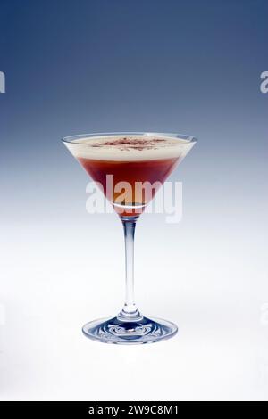 Une nature morte d'un martini au chocolat dans un élégant verre à martini photographié sur un fond Uni Banque D'Images