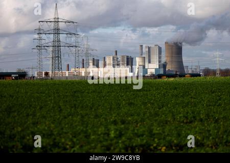 Impression vom RWE-Kraftwerk Bergheim Niederaußem. DAS Kohlekraftwerk zieht seine Schwaden in die kalte Winterluft. In der Umgebung glänzen Strommasten, Windräder und Wolkenformationen in der kalten Wintersonne. Stadtwerke geben bekannt : Strompreise steigen für Privathaushalte 2024 UM 32 Prozent. Grund ist eine Entscheidung der Bundesregierung, Gelder in Höhe von 5,5 Milliarden zur Stabilisierung der Netzentgelte zu streichen. Themenbild, Symbolbild. Bergheim, 26.12.2023 NRW Deutschland *** impression de RWEs centrale Bergheim Niederaussem la centrale à charbon coule dans le col Banque D'Images