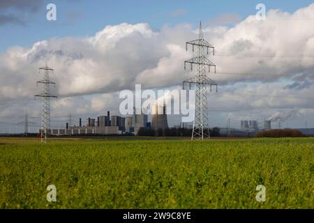 Impression vom RWE-Kraftwerk Bergheim Niederaußem. DAS Kohlekraftwerk zieht seine Schwaden in die kalte Winterluft. In der Umgebung glänzen Strommasten, Windräder und Wolkenformationen in der kalten Wintersonne. Stadtwerke geben bekannt : Strompreise steigen für Privathaushalte 2024 UM 32 Prozent. Grund ist eine Entscheidung der Bundesregierung, Gelder in Höhe von 5,5 Milliarden zur Stabilisierung der Netzentgelte zu streichen. Themenbild, Symbolbild. Bergheim, 26.12.2023 NRW Deutschland *** impression de RWEs centrale Bergheim Niederaussem la centrale à charbon coule dans le col Banque D'Images