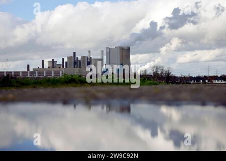 Impression vom RWE-Kraftwerk Bergheim Niederaußem. DAS Kohlekraftwerk zieht seine Schwaden in die kalte Winterluft. In der Umgebung glänzen Strommasten, Windräder und Wolkenformationen in der kalten Wintersonne. Stadtwerke geben bekannt : Strompreise steigen für Privathaushalte 2024 UM 32 Prozent. Grund ist eine Entscheidung der Bundesregierung, Gelder in Höhe von 5,5 Milliarden zur Stabilisierung der Netzentgelte zu streichen. Themenbild, Symbolbild. Bergheim, 26.12.2023 NRW Deutschland *** impression de RWEs centrale Bergheim Niederaussem la centrale à charbon coule dans le col Banque D'Images