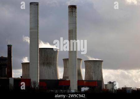 Impression vom RWE-Kraftwerk Bergheim Niederaußem. DAS Kohlekraftwerk zieht seine Schwaden in die kalte Winterluft. In der Umgebung glänzen Strommasten, Windräder und Wolkenformationen in der kalten Wintersonne. Stadtwerke geben bekannt : Strompreise steigen für Privathaushalte 2024 UM 32 Prozent. Grund ist eine Entscheidung der Bundesregierung, Gelder in Höhe von 5,5 Milliarden zur Stabilisierung der Netzentgelte zu streichen. Themenbild, Symbolbild. Bergheim, 26.12.2023 NRW Deutschland *** impression de RWEs centrale Bergheim Niederaussem la centrale à charbon coule dans le col Banque D'Images