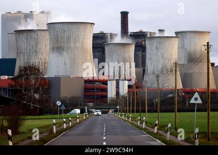 Impression vom RWE-Kraftwerk Bergheim Niederaußem. DAS Kohlekraftwerk zieht seine Schwaden in die kalte Winterluft. In der Umgebung glänzen Strommasten, Windräder und Wolkenformationen in der kalten Wintersonne. Stadtwerke geben bekannt : Strompreise steigen für Privathaushalte 2024 UM 32 Prozent. Grund ist eine Entscheidung der Bundesregierung, Gelder in Höhe von 5,5 Milliarden zur Stabilisierung der Netzentgelte zu streichen. Themenbild, Symbolbild. Bergheim, 26.12.2023 NRW Deutschland *** impression de RWEs centrale Bergheim Niederaussem la centrale à charbon coule dans le col Banque D'Images