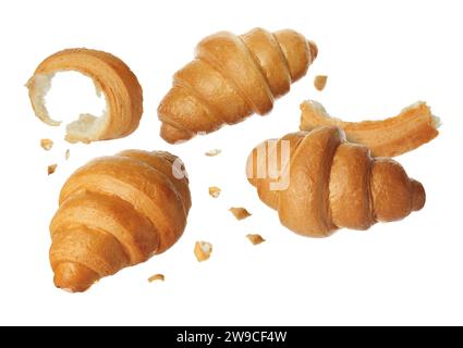 Délicieux croissants frais tombant sur fond blanc Banque D'Images