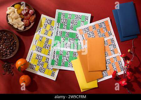 L'ensemble de loto est affiché sur la table avec des graines de melon, abricot sec salé, mandarines, fleurs de pêche et enveloppes porte-bonheur. Jeu pour le début Banque D'Images